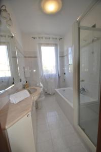 een witte badkamer met een bad, een wastafel en een douche bij Comfort Stay in Valpolicella, near Verona in San Pietro in Cariano