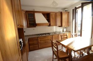 een keuken met houten kasten en een tafel met stoelen bij Comfort Stay in Valpolicella, near Verona in San Pietro in Cariano