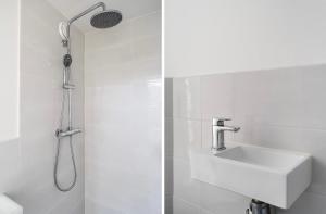 ein weißes Badezimmer mit Dusche und Waschbecken in der Unterkunft Cute cottage house in the city centre with terrace in Den Haag + 19 Fotos