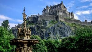 una estatua frente a un castillo en una montaña en Edinburgh Central Lauriston Aparthotel, en Edimburgo