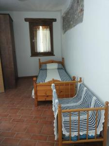 1 dormitorio con 2 camas en la esquina de una habitación en Alloggi Valle di Soffumbergo, en Valle