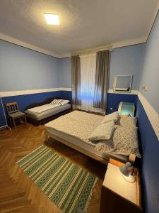 two beds in a room with blue walls at Irma Vendégház in Badacsonytomaj