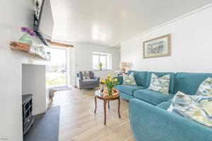 Una sala de estar con un sofá azul y una mesa. en Ysgubor-Bennar, en Dyffryn