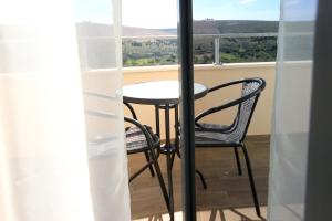 a table and chairs on a balcony with a view at B&B Ave Maria in Vrpolje