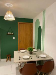 a dining room with a white table and chairs at Apartamento completo proximo as Praias do Litoral Sul in João Pessoa