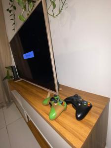 two video game controllers sitting next to a tv at Apartamento completo proximo as Praias do Litoral Sul in João Pessoa
