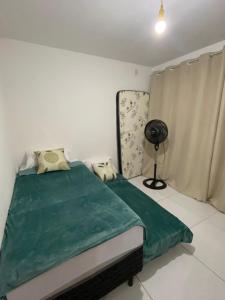 1 dormitorio con 1 cama verde y ventilador en Apartamento completo proximo as Praias do Litoral Sul, en João Pessoa 3 fotos más