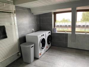 a laundry room with a washing machine and a window at Moderne Monteur- und Ferienwohnung am Plettenberg in Dotternhausen
