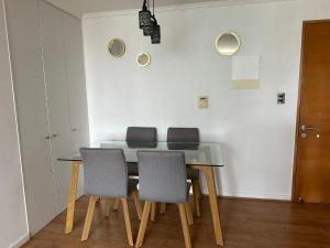 a dining room with a table and four chairs at Dpto 2 dormitorios cercano Aeropuerto in Concepción +14 photos