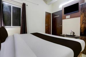KakarmathaにあるHotel O Royal Stay Innの白いベッドとテレビのある寝室