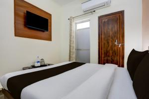 KakarmathaにあるHotel O Royal Stay Innのベッドルーム1室(ベッド1台付)、木製のドア