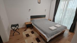 ein Schlafzimmer mit einem Bett mit zwei Handtüchern darauf in der Unterkunft Arini Urban Residence in Şelimbăr