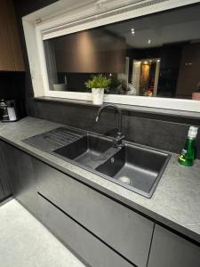 a kitchen counter with a sink and a mirror at Villa Brussel in Dilbeek