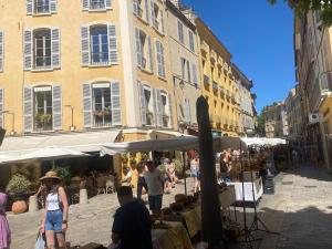 a group of people walking around a market in a street at Le Chabrier By La Familia in Aix-en-Provence