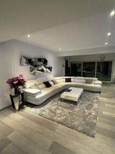 a living room with a white couch and a table at Villa Brussel in Dilbeek