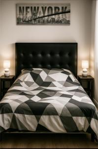 a bedroom with a bed with a black and white comforter at À 7 minutes de l'aéroport CDG 1 in Thieux