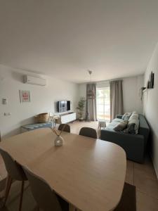 a living room with a table and a couch at Cabanas De Miramar in Tavira