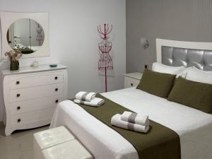 ein Schlafzimmer mit einem Bett mit einer Kommode und einem Spiegel in der Unterkunft El rincón de Cornelia en Tejeda in Tejeda