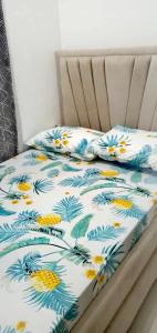 1 cama con edredón de flores y 2 almohadas en MJs Residence, en General Santos