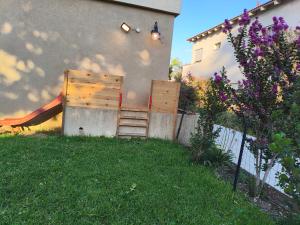 a backyard with a ladder and a fence and a house at אורן בשדה in Sede Ilan