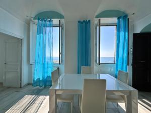 a dining room with blue curtains and a table and chairs at Casa al Prino in Imperia