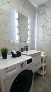 a white bathroom with a sink and a mirror at Droinvest Mieszkanie 2-pokojowe - Apartament Nysa, jezioro Nyskie, góry złote, fv in Nysa