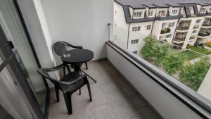 einen kleinen Tisch und einen Stuhl auf dem Balkon in der Unterkunft Arini Urban Residence in Şelimbăr