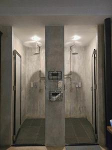 a bathroom with two shower stalls in a room at D Hostel by the river in Kanchanaburi City +63 photos