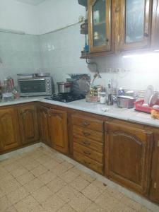 a kitchen with wooden cabinets and a stove top oven at Bouchaoui 