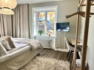 a bedroom with a bed and a desk and a window at Västerhöjdsgården in Skövde