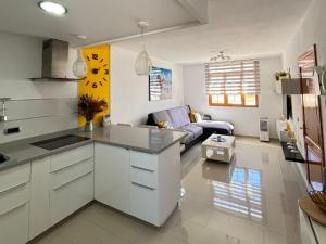 a kitchen and a living room with a couch at El rincón de Cornelia en Tejeda in Tejeda
