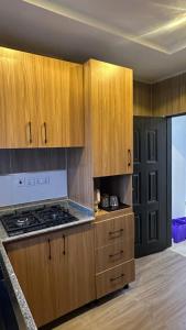 a kitchen with wooden cabinets and a stove at Continental apartments in Abuja