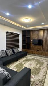 a living room with a couch and a flat screen tv at Continental apartments in Abuja