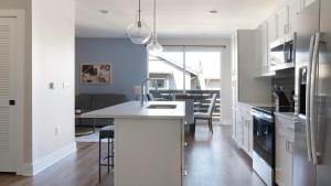 Una cocina con gabinetes blancos y una isla de cocina. en Landing Incredible 1BD Clubhouse Gym, en Oakwood