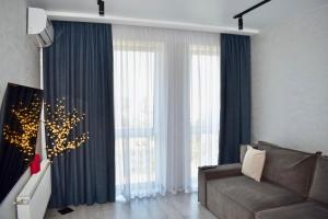 a living room with a couch and a large window at Дизайнерські апартаменти в ЖК DreamTown 10б in Luts'k