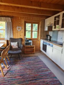 a kitchen with a couch and a chair in a cabin at Biohof Schwanser in Steinbach am Attersee