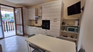 a kitchen with a table with chairs and a television at Cavallo Blu in Clusane sul Lago +11 photos