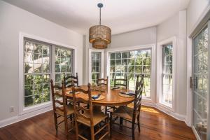 a dining room with a table and chairs and windows at Indigo San' in Edisto Island