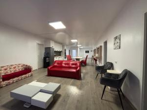 a living room with a red couch and chairs at Bob Residence- Chic Penthouse in Cluj-Napoca