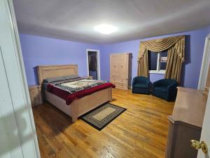 a bedroom with blue walls and a bed and two chairs at White House Canada in Brampton +62 photos