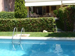 a swimming pool in front of a house at Apartamento Playa in S'Agaro +21 photos