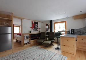 a kitchen with a counter and chairs in a room at Haus am Rain in Partenen