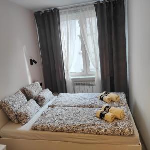 a bedroom with a bed with two pillows on it at Apartament Krakowska in Tarnowskie Góry