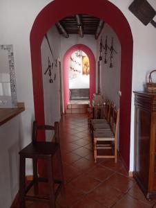 Zimmer mit einem Torbogen mit Stühlen und einem Tisch in der Unterkunft Casa La Zorrina in Cortelazor