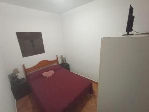 ein Schlafzimmer mit einem Bett mit einer lila Tagesdecke in der Unterkunft Casa La Zorrina in Cortelazor