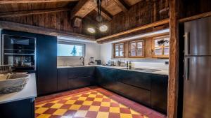 a kitchen with a checkered floor at DoneoCasaVacanze LuxHome in Cortina dʼAmpezzo