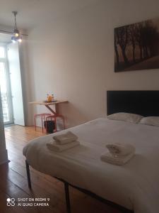 a bedroom with a bed with two towels on it at Happy at Chiado in Lisbon