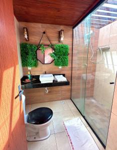 a bathroom with a toilet and a glass shower at Chalé Adventure - Serra de São Bento RN in Serra de São Bento