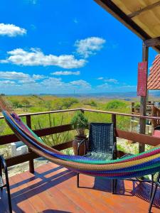 a hammock and a chair on a deck with a view at Chalé Adventure - Serra de São Bento RN in Serra de São Bento