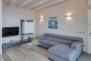 un salon avec un canapé et une télévision dans l'établissement La Giolosa Gardapartments, à Moniga del Garda